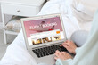 © New Africa - Woman using laptop to book flight at home, closeup
