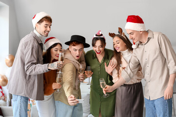 Wall Mural - Group of friends with champagne taking selfie at New Year party