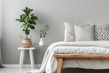 Grey Bedroom With A Wooden Bench Patterned Pillows On Bed And A Plant On A White Nightstand