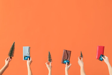 Wall Mural - Women with credit cards, toy Christmas trees and wallets on orange background