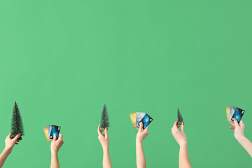 Poster - Women with credit cards and toy Christmas trees on green background