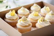 Close up selective focus of lemon cupcakes with white cream in cupcake packaging inside a delivery box