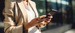© AspctStyle - Close Up of Woman in Beige Blazer Using Smartphone on Sunny City Street