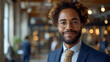 Close-up view of a smiling and confident African American male business executive - CEO - Professor - Office worker - blurred background - motivated black professional 