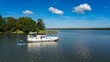 © Iuliia Sokolovska - Houseboat in lake aerial view from above, people having fun in water on supboard, family travel by barge boat and vacation in lake district, Germany