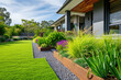© Kien - A contemporary Australian home or residential buildings front yard features artificial grass lawn turf with timber edging, and a big flowers garden