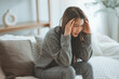 © oatawa - Depressed young woman sitting on couch in the living room at home, Frustrated confused female feels unhappy problem in personal life quarrel break up with boyfriend