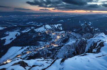 Canvas Print - Carpathian winter mountain village in light with wooden houses on a hill covered with fresh snow.