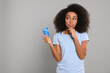 © New Africa - Woman with credit card on grey background, space for text. Debt problem