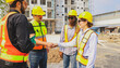 © ฺฺฺBoonterm - Teamwork handshake cooperation of architects and male and female workers multiethnicon on the apartment construction site condominium building for success in the project teamwork and achieving goals.