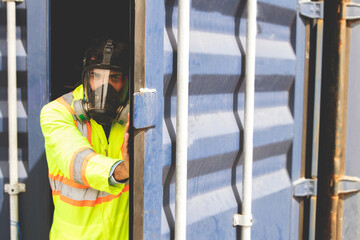 Male rescue worker wearing uniform PPE and wear mask to prevent accidents from dangerous stench toxins inside the container that are illegally transported into the country. Open the door carefully.