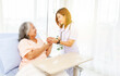 © ฺฺฺBoonterm - Female doctor holds the hand elderly female patient showing positive expressions encouragement good wishes each other heal sick person normal healthy spread happiness together in the hospital.