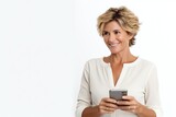 Fototapeta Uliczki - Smiling mature woman with a smartphone isolated on a white background