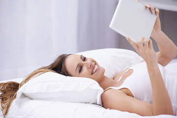 Poster - Happy woman, bed and relax with tablet for social media, communication or networking at home. Female person smile lying in bedroom on pillow with technology for online streaming or entertainment