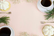 Filiżanki kawy i eleganckie białe babeczki ślubne. Z miejscem na tekst, na jasnym różowym tle. 