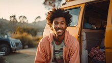 Black Man Smiling Sitting Next To His Orange Camper Van