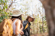 © Natee Meepian - Lovely couple lesbian woman with backpack hiking in nature. Loving LGBT romantic moment in mountains