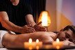 The hands of the male masseur are actively rubbing the visitors back, a therapeutic massage for tired muscles. Point massage in the spa center. Body therapy for a healthy lifestyle.