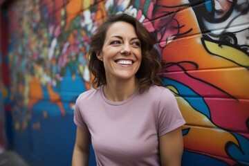 Wall Mural - Portrait of a smiling woman in her 40s sporting a vintage band t-shirt against a colorful graffiti wall. AI Generation