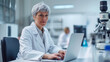 © Marta B - mature female scientist is working on a laptop in a laboratory