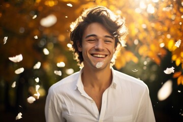 Wall Mural - Portrait of a joyful man in his 20s wearing a classic white shirt against a background of autumn leaves. AI Generation