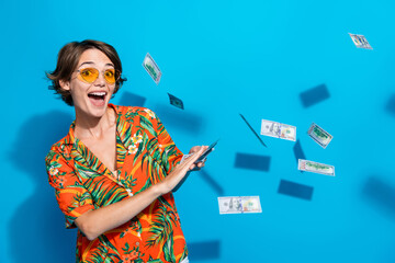 Poster - Photo of crazy positive person hands hold throw flying dollar banknotes isolated on blue color background