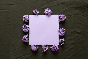 Wall Mural - Blank card for text, lilac flowers on textile green background. Beautiful flowers composition. Valentines Day, Easter, Birthday, Happy Women's Day, Mother's day. Flat lay, copy space, top view