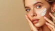 © Максим - Close-up of a beautiful girl's face applying skin cream to her face.