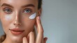 © Максим - Close-up of a beautiful girl's face applying skin cream to her face.