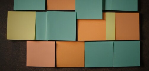 Canvas Print -  a close up of a wall made out of different colored pieces of paper with a brown background and a black wall in the middle of the room with a brown floor.