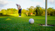 © somchai - Golfer putting ball on the green golf, lens flare on sun set evening time.