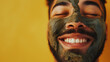 Mixed race man wearing a mud clay face mask, male skincare pampering regimen, against a yellow background with copy space ai generated