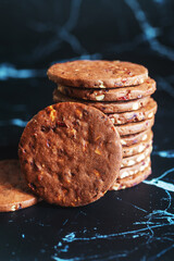 Wall Mural - A stack of chocolate shortbread with fruits and nuts on marble background