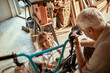 © Marko Geber - Grandfather and grandson fixing a bike in the garage