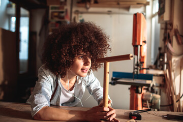 Wall Mural - Happy female carpenter working on a woodworking project in workshop