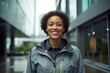 Portrait of a satisfied afro-american woman in her 30s sporting a waterproof rain jacket against a sophisticated corporate office background. AI Generation