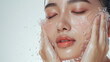 Woman washing face enjoying a refreshing water splash in a spa, radiating beauty and wellness Facial care with a bright smile, Water droplets on the face, close-up of the face Banner for ads.