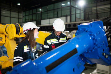 Wall Mural - Both of engineers working together in a robotic arm factory, Robotic arm industry and engineering concept.