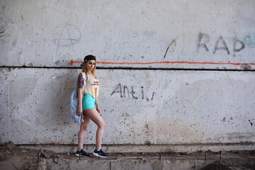 Wall Mural - Portrait of Young Woman on Wall Background. Trendy Urban Fashion Concept. Outdoor closeup portrait of young sexy crazy girl