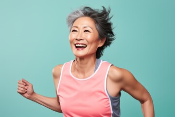 Portrait of a happy asian woman in her 50s wearing a lightweight running vest against a pastel or soft colors background. AI Generation