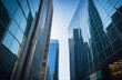 © Marina Demidiuk - Financial district area bottom view among blue sky. Modern office building or business center. High-rise buildings made of glass reflect the clouds and the sunlight. Looking directly up. Skyscrapers