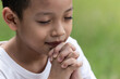 Little boy with Bible praying and close your eyes in praying. Prayer to pray. Children pray with folded hands.
