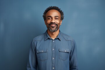 Wall Mural - Portrait of a content afro-american man in his 40s sporting a versatile denim shirt against a solid color backdrop. AI Generation