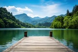 Fototapeta  - Serene lake view with wooden dock and mountain backdrop. Nature background.