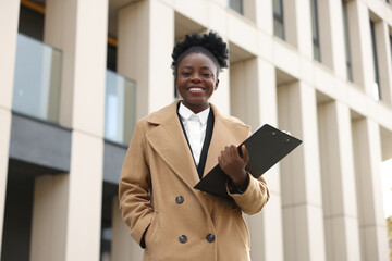 Canvas Print - Happy woman with clipboard outdoors. Lawyer, businesswoman, accountant or manager