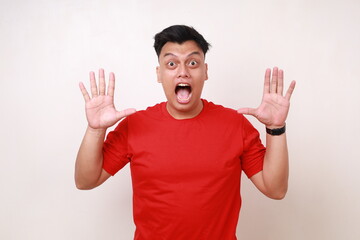 Wow shocked funny asian man shouting looking at the camera. Isolated on white