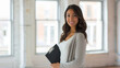 © MP Studio - Young woman with a pleasant smile, holding a clipboard in her hands.