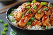 Chicken teriyaki made of chicken breast fillets, sweet Japanese wine, freshly grated ginger, soya sauce, green onions for garnish served in bowl