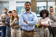 African American boss standing in front of his colleagues in the office