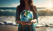  Jovem ativista na praia segurando o globo do planeta Terra na mão em ação climática e conceito de conservação ambiental